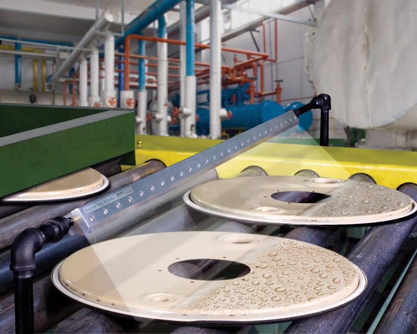 Exair - Air Knife An Exair air knife drying discs on a conveyor